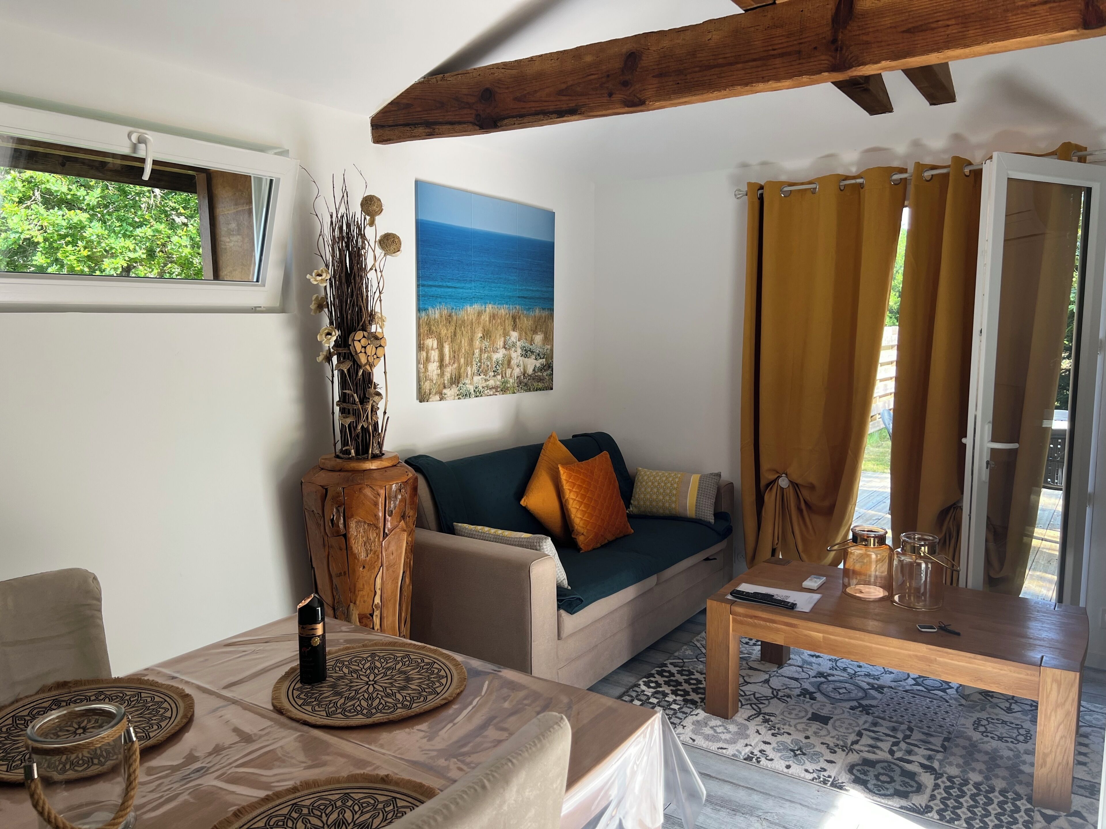 A living room with a sofa, coffee table, and a painting of a beach scene.