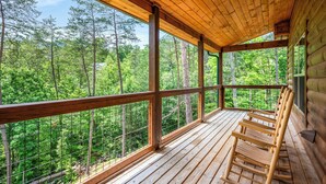 Una terraza de madera con vistas a un bosque.