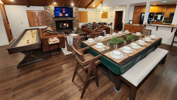 Un salón amplio con chimenea, televisor y comedor listo para una comida.