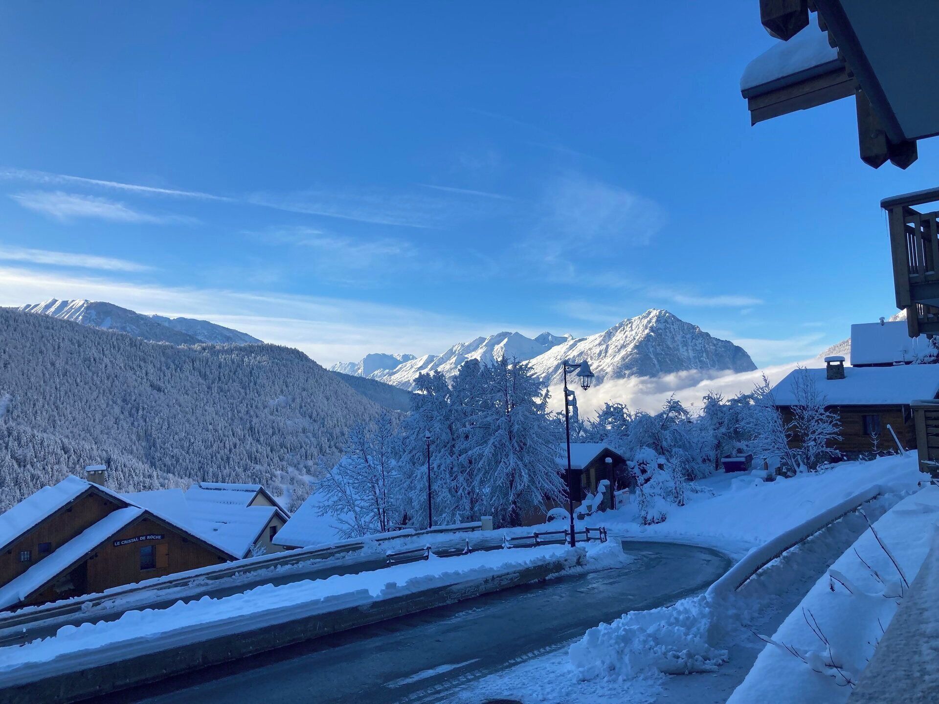 Ett snötäckt berglandskap med en träbyggnad som har skylten ”LE CRISTAL DE ROCHE”.