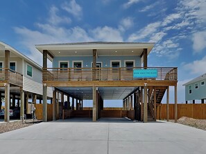 A two-story building with a balcony and a sign that reads "WASH AWAY THE BLUES." - Wash Away the Blues by Silver Sands Vacation Rentals (Port Aransas)