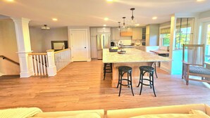 A spacious kitchen with a large island, wooden flooring, and modern appliances. - Newly remodeled, private Villa in Bolton Landing with all the comforts of home (Bolton)