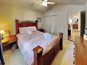 A bedroom with a bed, a nightstand, a bedside lamp, a ceiling fan, and a wardrobe. - The Bungalow by Ruidoso Vacation Rentals (Ruidoso)