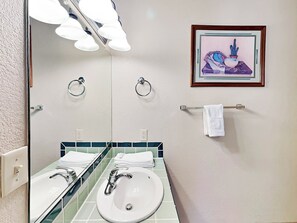 A bathroom with two sinks, a mirror, and a framed artwork on the wall. - The Bungalow by Ruidoso Vacation Rentals (Ruidoso)
