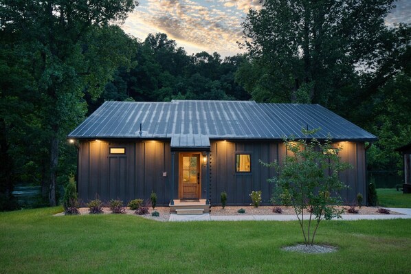 A modern house with a metal roof, a front porch, and a well-maintained lawn. - Juneburger Chalet on The Watauga River (Johnson City)