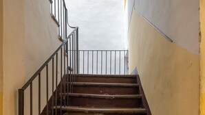 Egy lépcső, melynek fém korlátjai a felső szintre vezetnek.