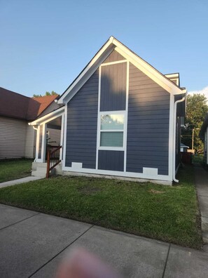 A single-story house with a gable roof, a front porch, and a small attached garage. - Cozy 3-bedroom house near Lucas Oil Stadium in downtown Indianapolis.  (Indianapolis)