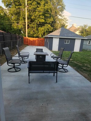 A concrete patio with a table and four chairs. - Cozy 3-bedroom house near Lucas Oil Stadium in downtown Indianapolis.  (Indianapolis)