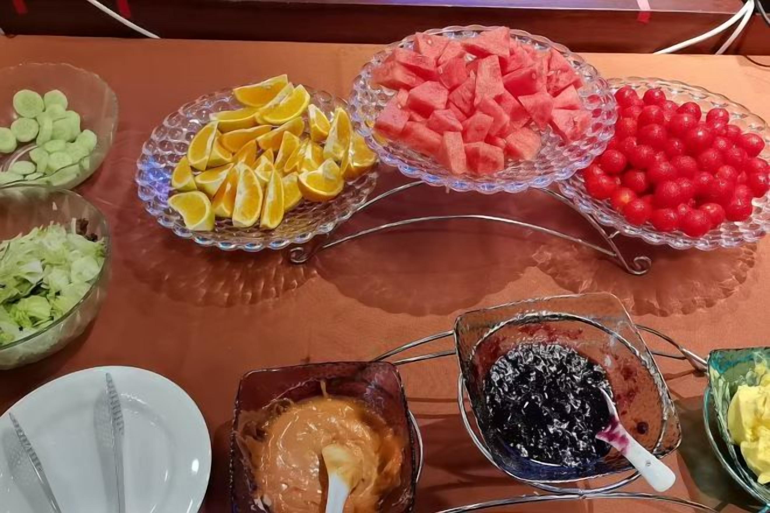 A buffet table with various food items including fruits, vegetables, and dips.