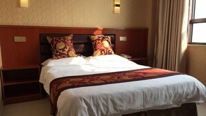 Habitación de hotel con una cama grande, dos mesitas de noche y un ventanal con cortinas.