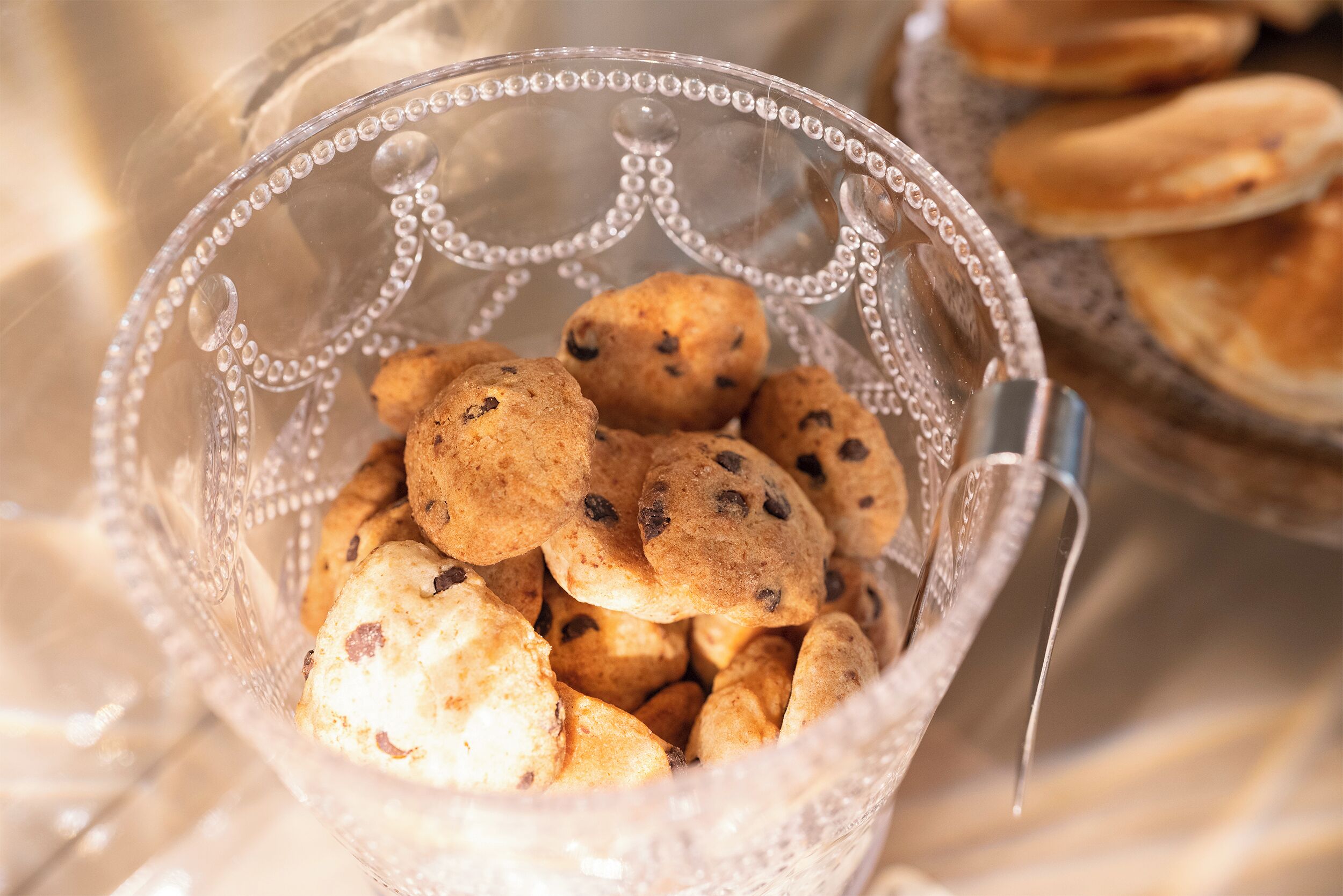 A clear glass bowl filled with cookies.
