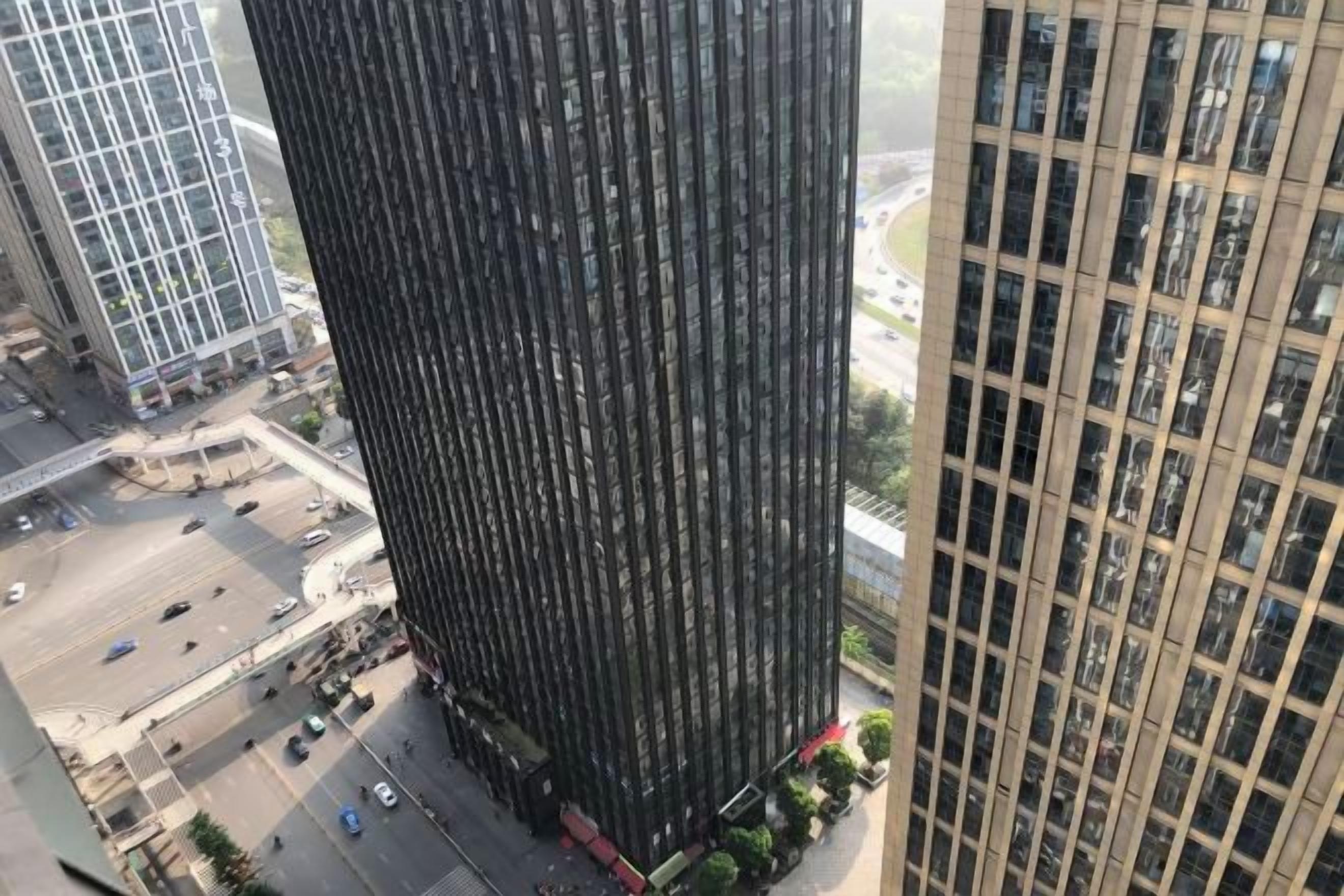 A tall building with a grid-like facade, surrounded by other high-rise structures.