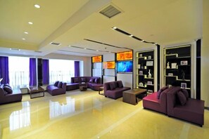 A modern hotel lobby with a seating area, large windows, and a television screen. - Lavande Hotel (Guiyang Huaguoyuan Caifu Plaza) (Guiyang)