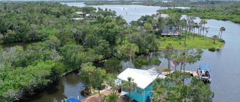 Una casa flotante amarrada en un puerto deportivo, rodeada de un denso bosque de manglares.