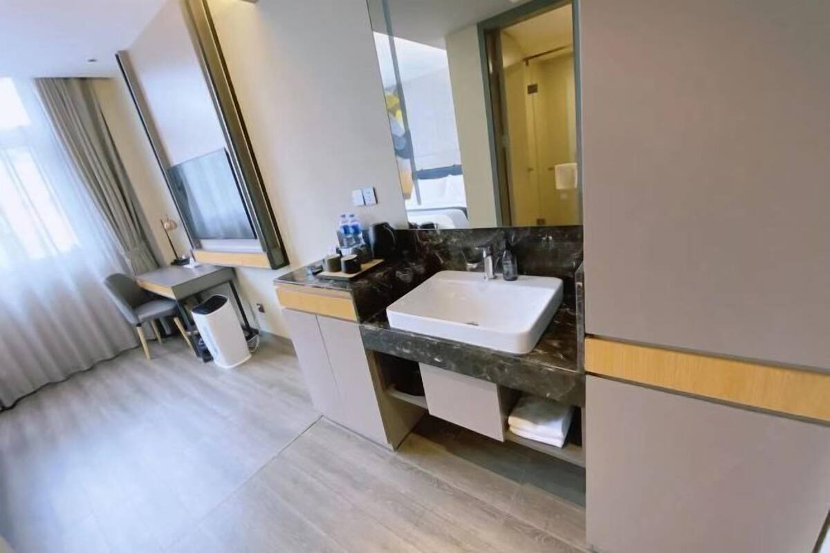 A modern bathroom with a large mirror, a sink, and a vanity.