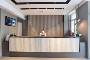 A reception desk with a modern design, a digital display, and a window providing natural light. - Homeinn Selected Hotel (Beijing Deshengmen Outer Street) (Beijing)