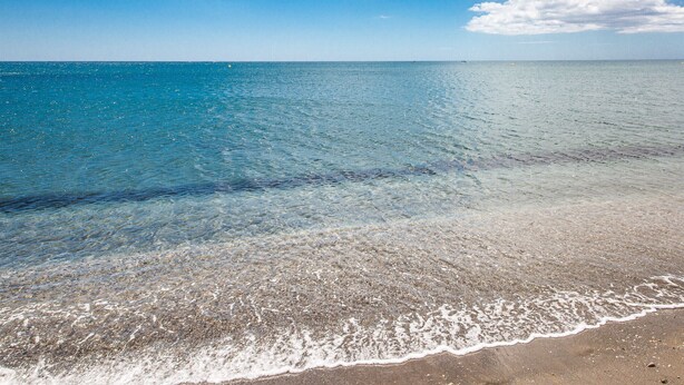 A beach with clear shallow waters and a sandy shore. - Gunilla townhouse no 6 (Manilva)