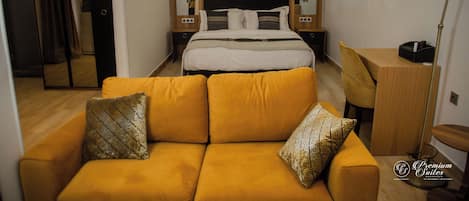 Una habitación de hotel moderna con una cama grande, un sofá, un escritorio y un espejo.