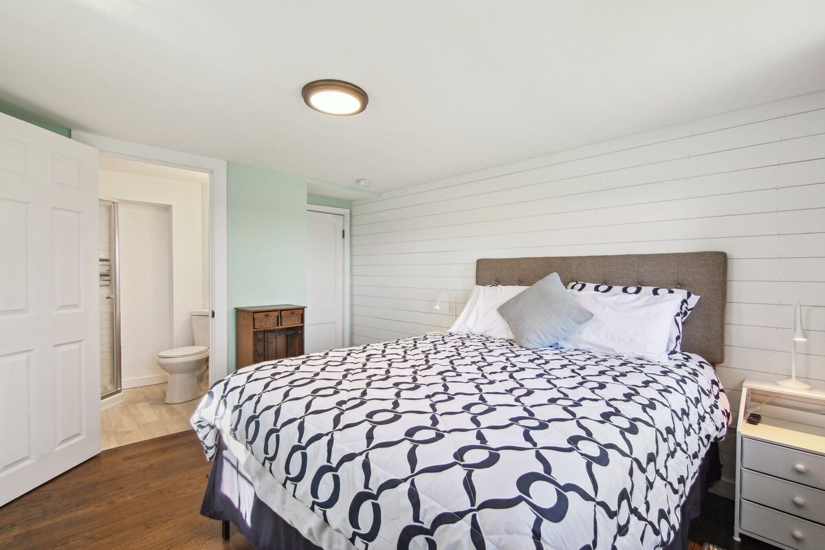 A bedroom with a bed, bedside table, and a nightstand.