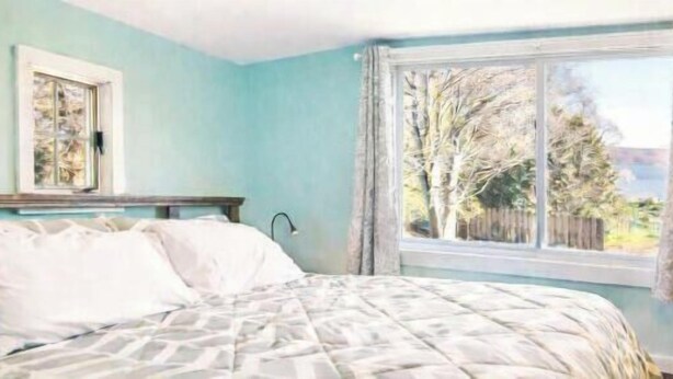 A bedroom with a bed, a window, and a lamp. - The Cottage Inn At Amos Lake (Preston)