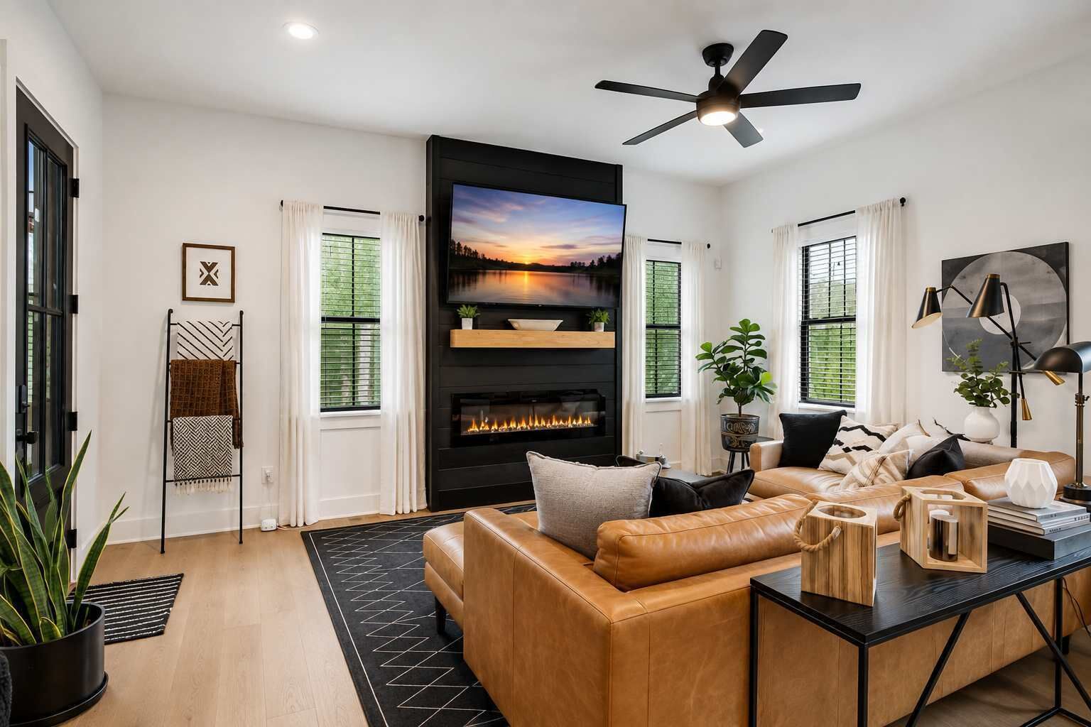 Una sala de estar moderna con chimenea, sofá de cuero y televisor de pantalla plana.