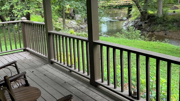 Eine Holterrasse mit Geländer, die auf einen Fluss und üppige Vegetation blickt.