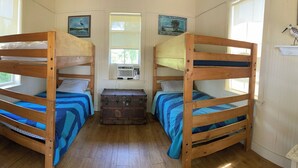 A room with two bunk beds, a chest of drawers, and a chair. - Jiggs Landing, Cabin 2 - Bird Land Bunk House (Manatee County)