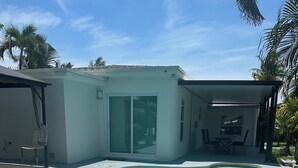 A modern house with a swimming pool, a covered patio, and a dining area. - Pool entire house 3bed 2bath and sofa bed  (North Miami Beach)