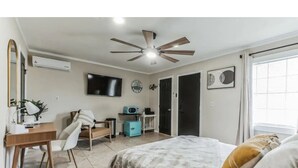 A bedroom with a bed, a desk, a chair, a television, and a ceiling fan. - Welcome to Casa Bugambilia  (Weslaco)