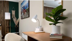 A modern office desk with a white desk lamp, a potted plant, and a framed picture on the wall. - Welcome to Casa Bugambilia  (Weslaco)