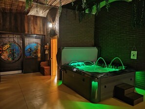 A spa area with a hot tub, wooden walls, and a mural.