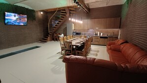 Een moderne keuken met houten kastjes en een eethoek met tafel en stoelen.