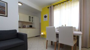 A compact living space with a dining area, kitchenette, and a sofa.