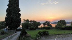 A gravel path leading to a grassy area with a view of a sunset over a body of water. - MATIKA One-Bedroom Apartment with Terrace (Rovinj)