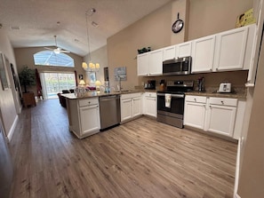 A kitchen with white cabinets, a microwave, an oven, and a dishwasher.