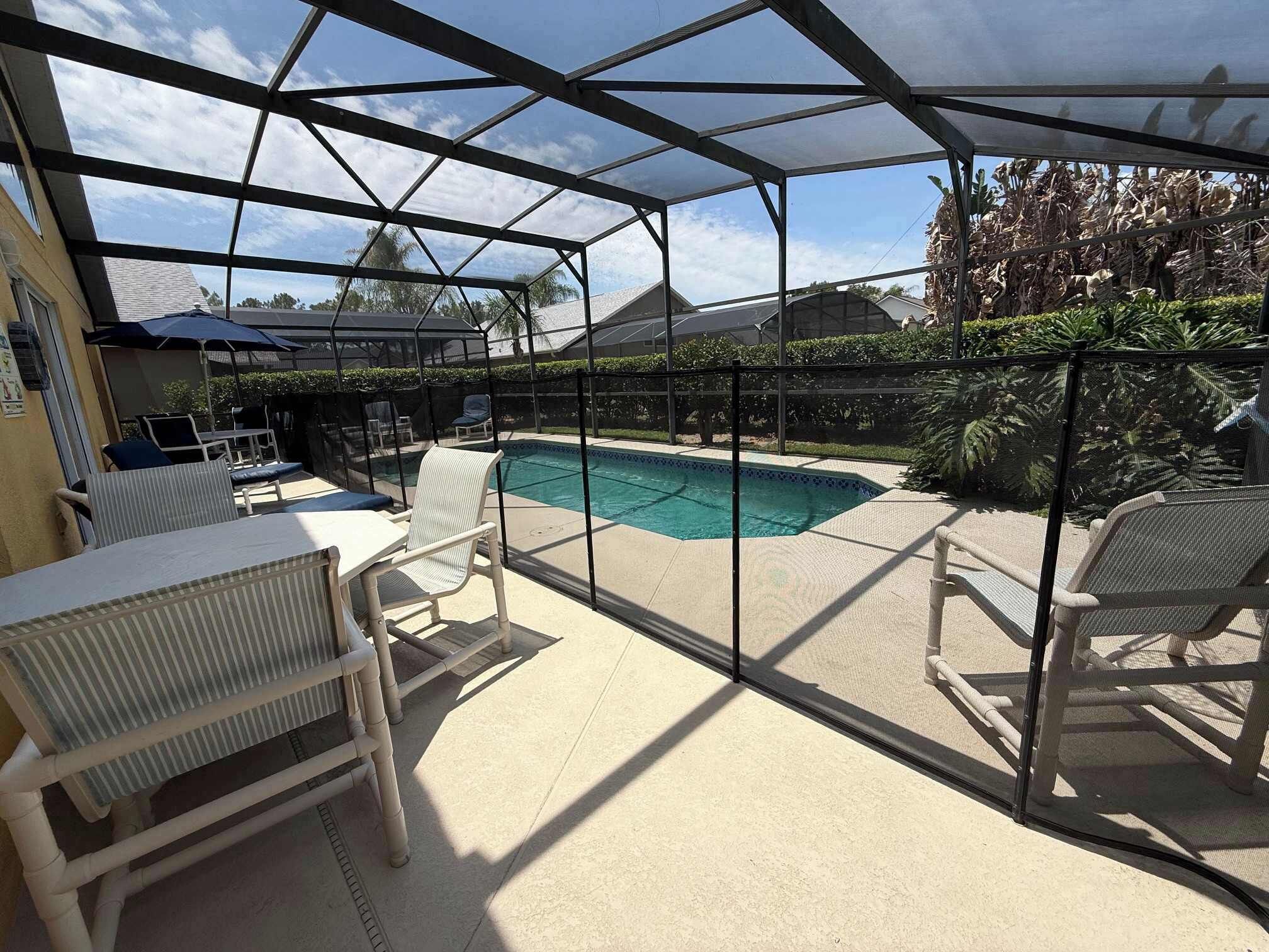 Un espacio al aire libre techado con piscina, sillas y sombrillas.