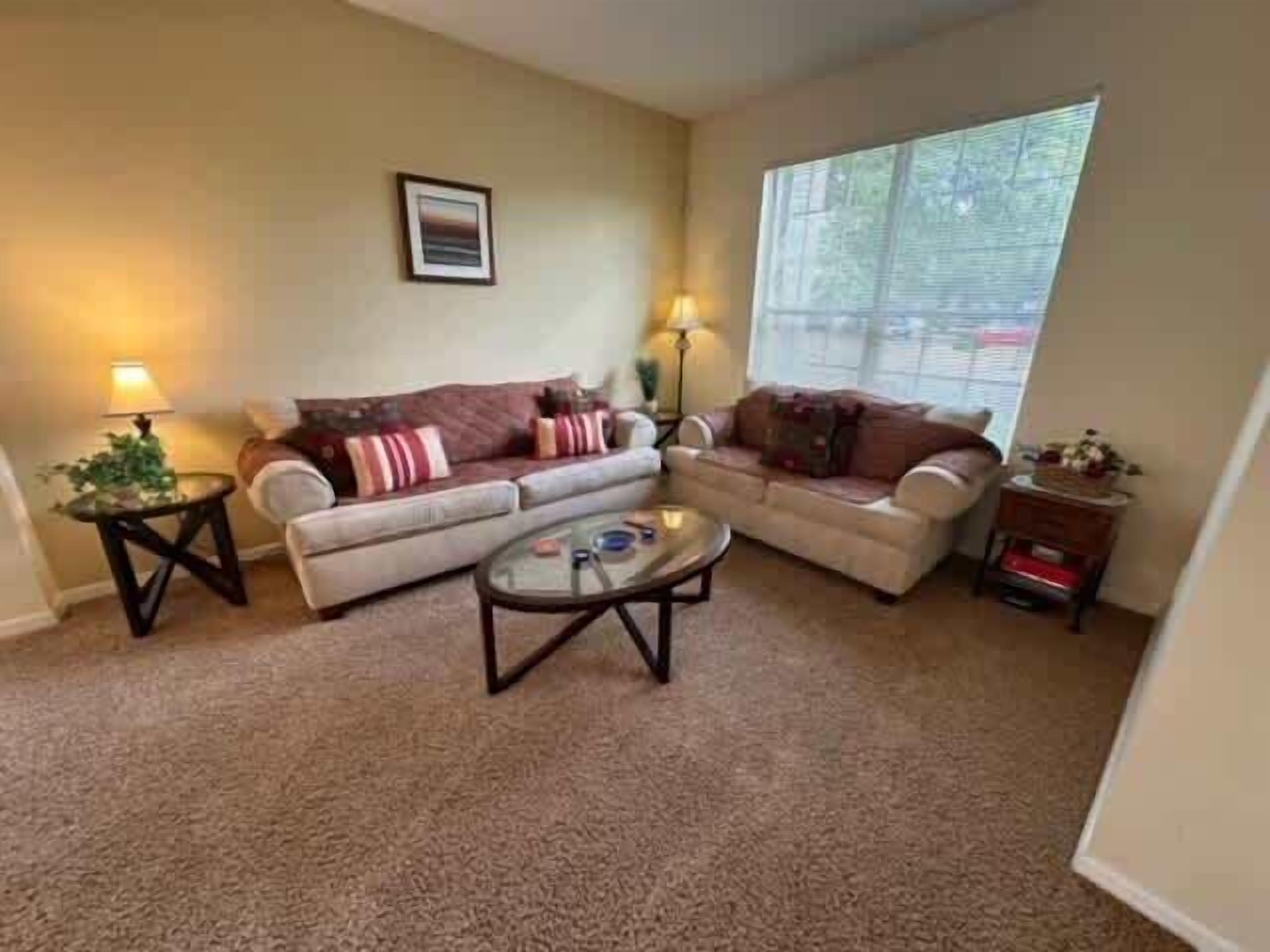 A living room with two sofas, a coffee table, and two lamps.