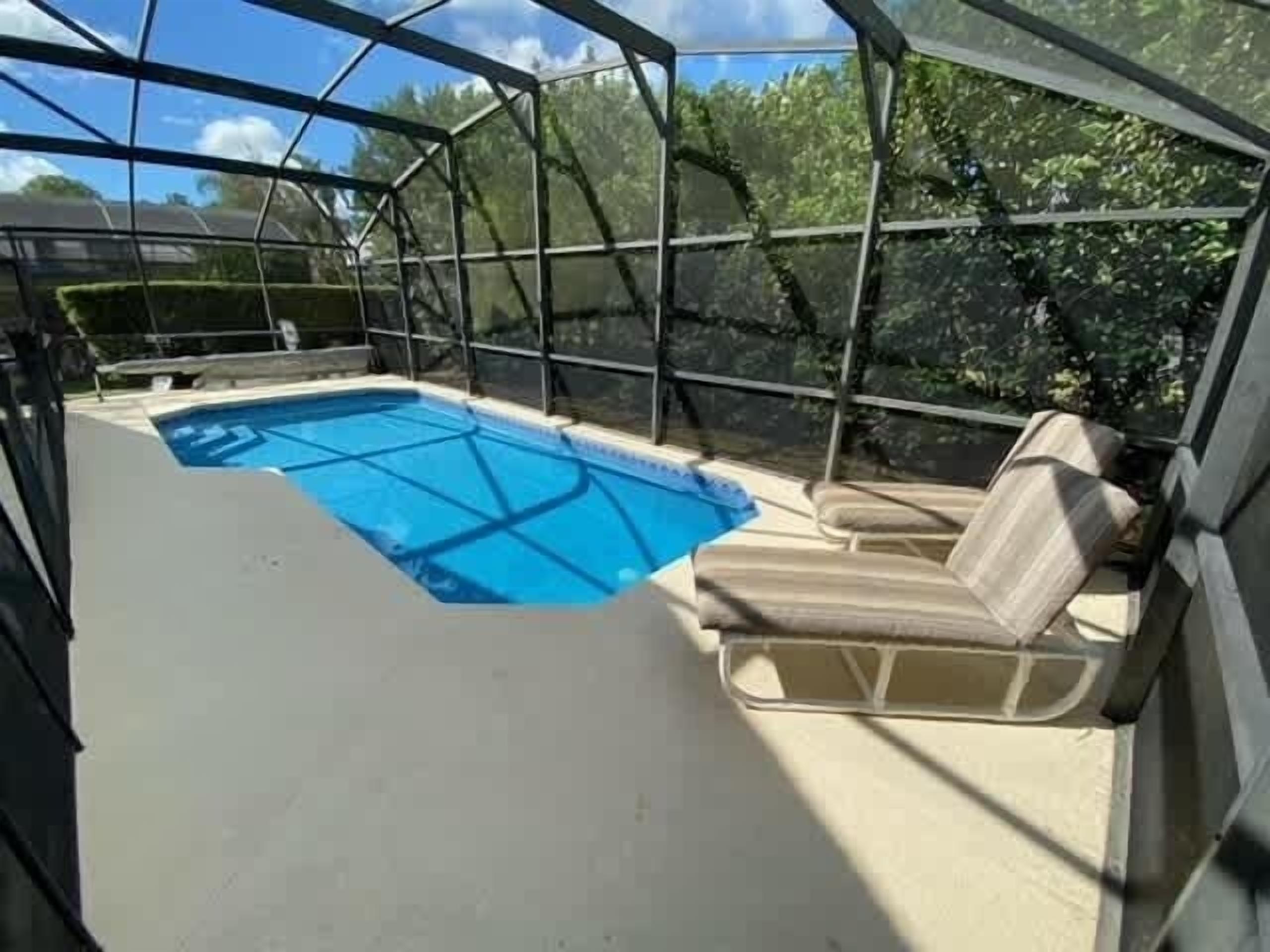 Ein überdachter Pool im Freien mit Blick auf B äume und einen klaren Himmel.