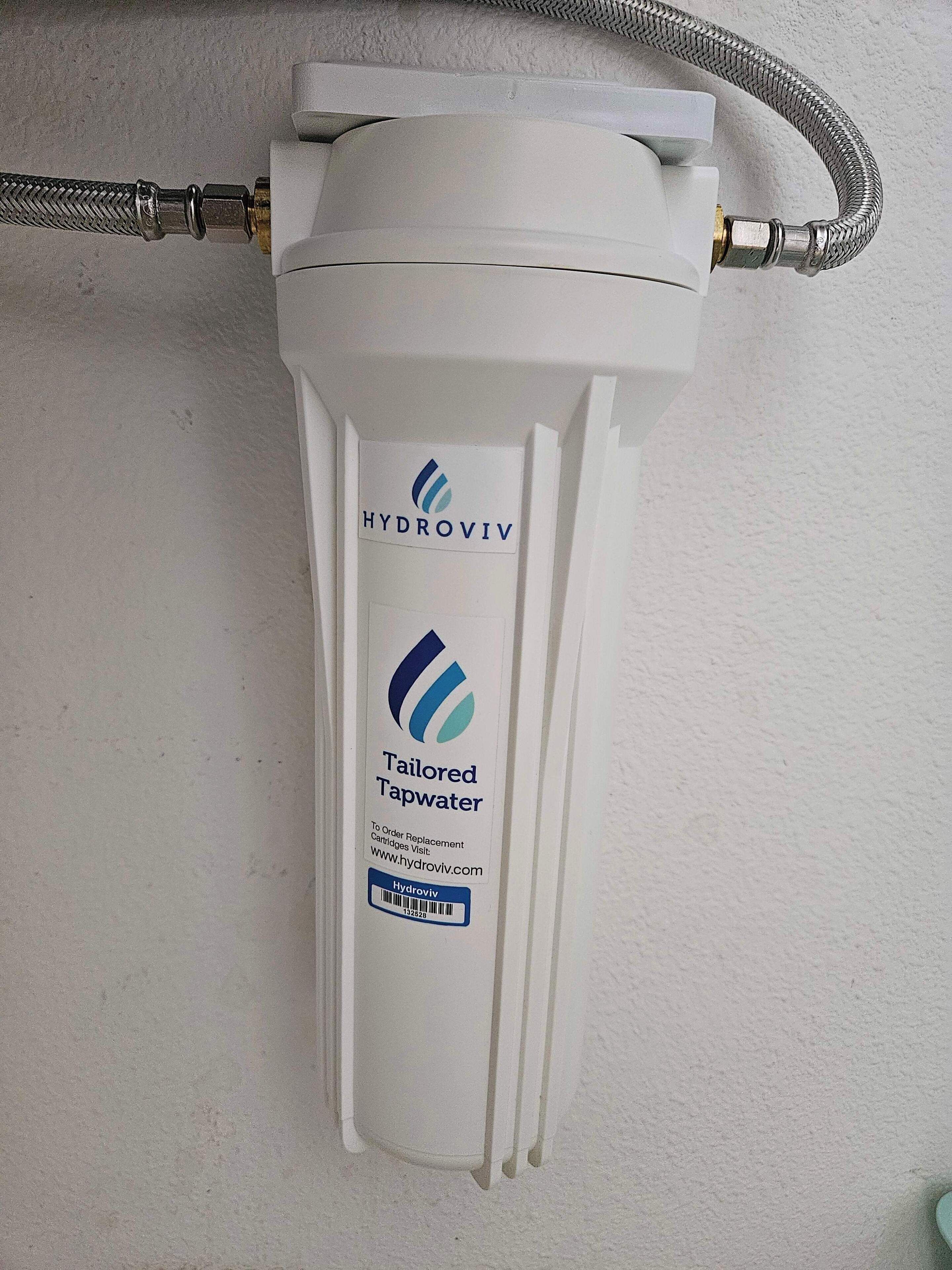 Een waterfilter voor kraanwater, wit van kleur, met een Hydroviv label, een slang en een barcode.