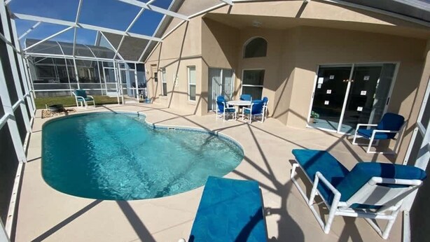 Ein Poolbereich mit Liegestühlen und einer überdachten Terrasse.