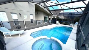 Ein Innenpool mit Whirlpool, Liegestühlen und einer Glaskuppeldecke.