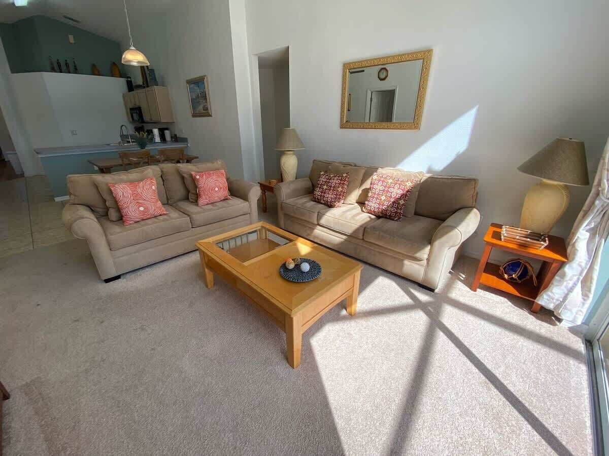 A living room with two sofas, a coffee table, and a lamp.