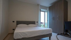 A bedroom with a bed, a wardrobe, and a balcony. - Hice Room (Catanzaro)