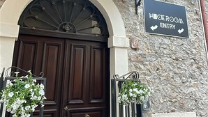 A hotel entrance with a dark wooden door, an arched window above, and a sign indicating "HICE ROOM ENTRY". - Hice Room (Catanzaro)