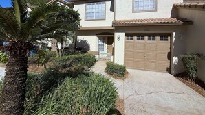 A two-story house with a garage, a palm tree, and a well-maintained garden. - The Solterra Sanctuary (Haines City)