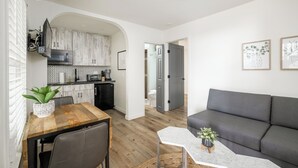 A modern apartment with a dining area, kitchen, and living room. - First Floor King Suite (101) (Oceanside)