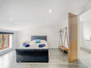 A modern bedroom with a bed, bedside tables, a hanging chair, and a large window. - 5 bedroom accommodation in Belper (Belper)