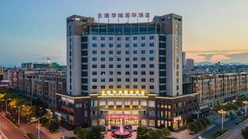 A multi-story hotel with a central entrance, surrounded by other buildings.