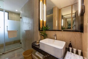 A modern bathroom with a large mirror, a white bathtub, and a glass-enclosed shower area.