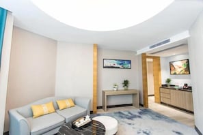 A modern living room with a sofa, a coffee table, and a TV. - Good China City International Hotel (Xingan)